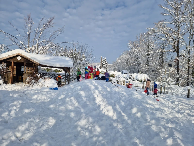 Kinder am Schneehügel beim Bobfahren